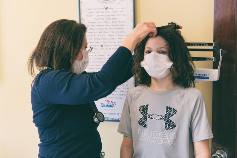 a woman measuring the height of a boy