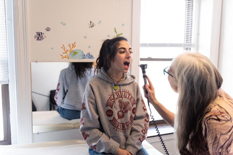 a teen girl getting her throat examined